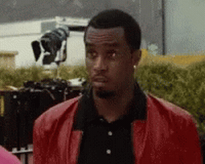 Man In Red Jacket And Black Shirt Looking GIF