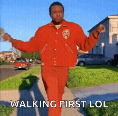 Man In Red Jacket And Red Pants Walking Down Sidewalk GIF