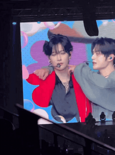 Man In Red Jacket Being Held By Another Man GIF