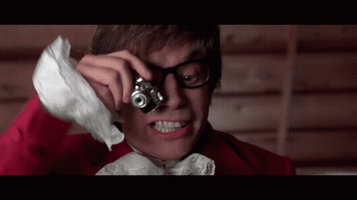 Man In Red Jacket Holding Camera Over Eye GIF