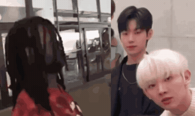 Man In Red Jacket Holding Gun In Front Of CBE Sign GIF