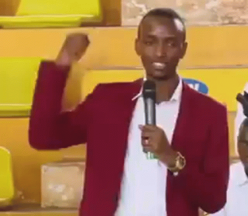 Man In Red Jacket Holding Microphone Raising Fist GIF