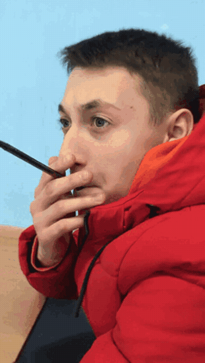 Man In Red Jacket Holding Phone To Nose GIF