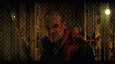 Man In Red Jacket Holding Sword In Dark Room GIF