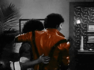 Man In Red Jacket Hugging Another Man In Black And White Photo GIF