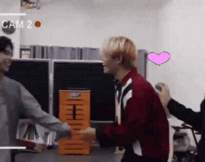 Man In Red Jacket Hugging Another Man With Cam 2 On Wall GIF