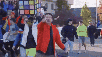 Man In Red Jacket In Front Of Crowd GIF