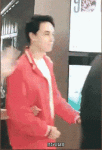 Man In Red Jacket In Front Of Hawaii Sign GIF