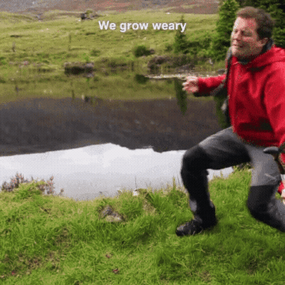 Man In Red Jacket Kneeling Near Lake GIF