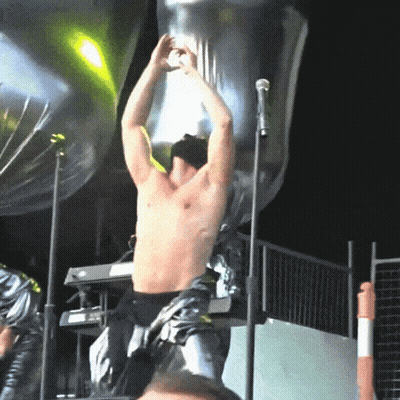 Man In Red Jacket On Stage With Bag On Head GIF