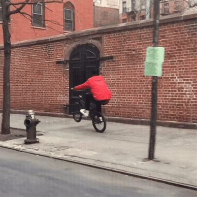 Man In Red Jacket Riding Bike Beside Fire Hydrant GIF