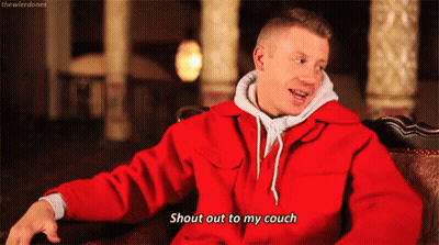 Man In Red Jacket Sitting On Couch Talking GIF