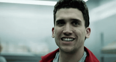 Man In Red Jacket Smiling In Dark Room GIF