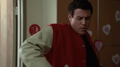 Man In Red Jacket Standing Before Heart Wall GIF