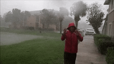 Man In Red Jacket Standing In Rain Before Hurricane GIF