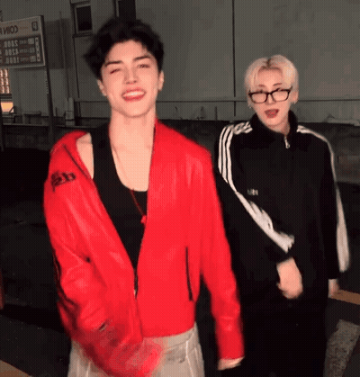 Man In Red Jacket Standing Next To Another Man GIF
