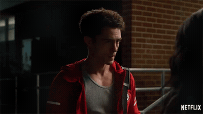 Man In Red Jacket Standing Next To Woman In Front Of Brick Wall GIF