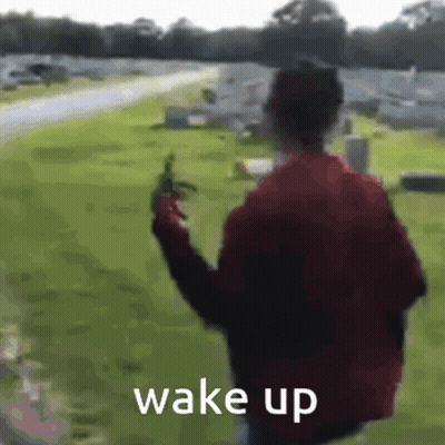 Man In Red Jacket Walking Through Cemetery With Gun Saying Wake Up GIF