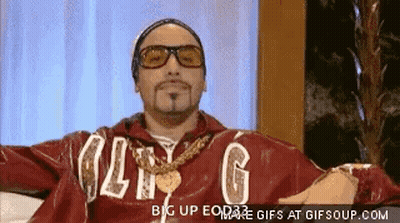 Man In Red Jacket With Letter G Arms Outstretched On Couch GIF