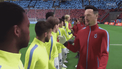 Man In Red Jacket With Letter O Shaking Hands With Soccer Players GIF