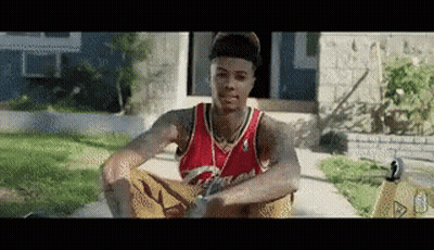 Man In Red Jersey Sitting Beside Yellow Caution Sign GIF