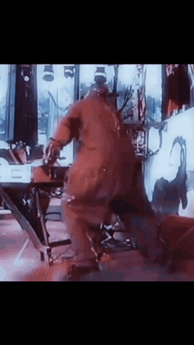Man In Red Jumpsuit Dancing On Stage GIF