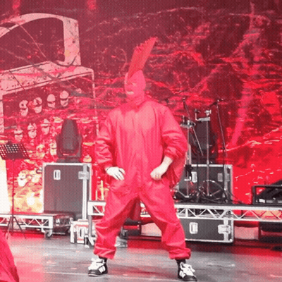 Man In Red Jumpsuit Dancing With Drum Set GIF