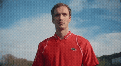 Man In Red Lacoste Shirt Against Blue Sky GIF
