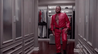 Man In Red Leather Suit Walking Down Closet GIF