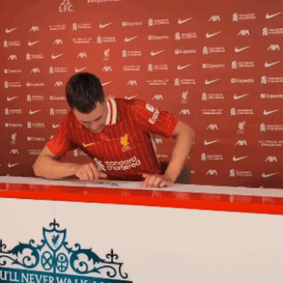 Man In Red Liverpool Jersey Signing Paper GIF