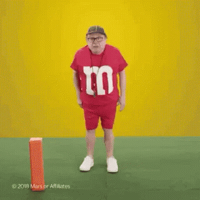 Man In Red M&Ms Shirt Dancing On Field GIF