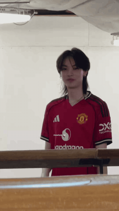 Man In Red Manchester United Jersey Standing By Table GIF