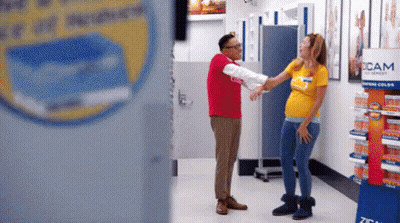 Man In Red Next To Pregnant Woman In Yellow GIF