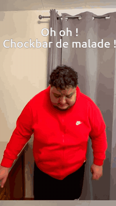 Man In Red Nike Sweatshirt Standing In Front Of Grey Curtain GIF