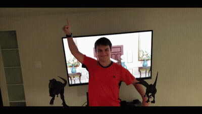 Man In Red North Face Shirt Standing In Front Of TV GIF