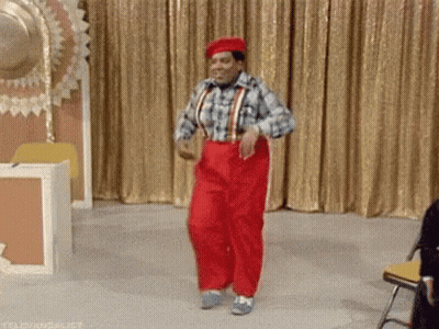 Man In Red Pants Dancing On Stage In Front Of Gold Curtain GIF