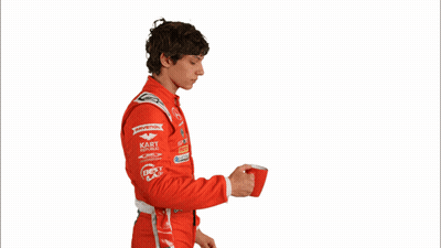 Man In Red Racing Suit Drinking From Red Container GIF