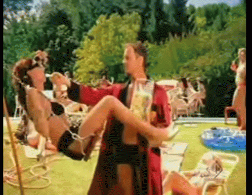 Man In Red Robe Carrying Woman In Bikini GIF