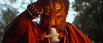 Man In Red Robe Holding Small Statue GIF