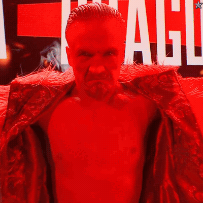 Man In Red Robe In Front Of League Sign GIF