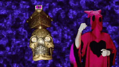 Man In Red Robe Next To Skull GIF