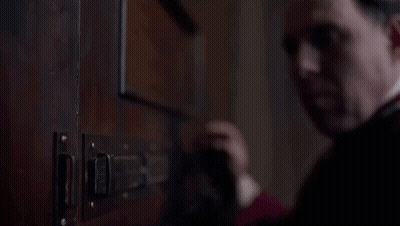 Man In Red Robe Opening Door With Latch GIF