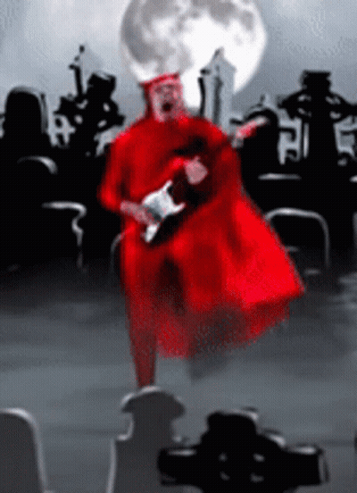Man In Red Robe Playing Guitar In Cemetery With Full Moon GIF