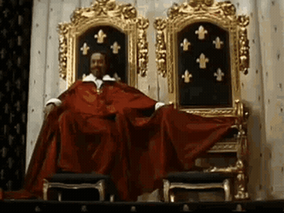 Man In Red Robe Sitting On Throne With Gold Chairs GIF