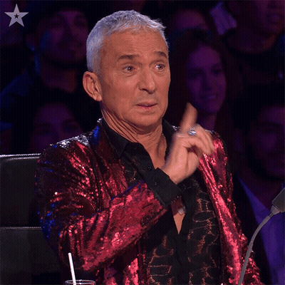 Man In Red Sequined Jacket Sitting Before Crowd GIF