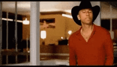 Man In Red Shirt And Cowboy Hat By Window GIF