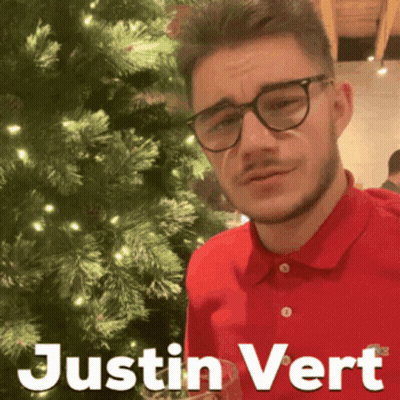 Man In Red Shirt And Glasses In Front Of Christmas Tree GIF