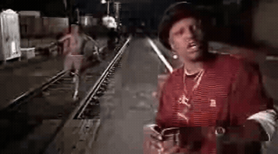 Man In Red Shirt And Hat On Train Track At Night GIF
