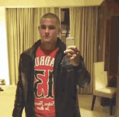 Man In Red Shirt And Leather Jacket Taking Selfie GIF
