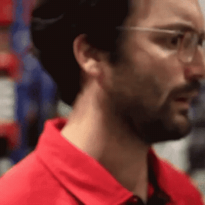 Man In Red Shirt And Safety Glasses Looking GIF